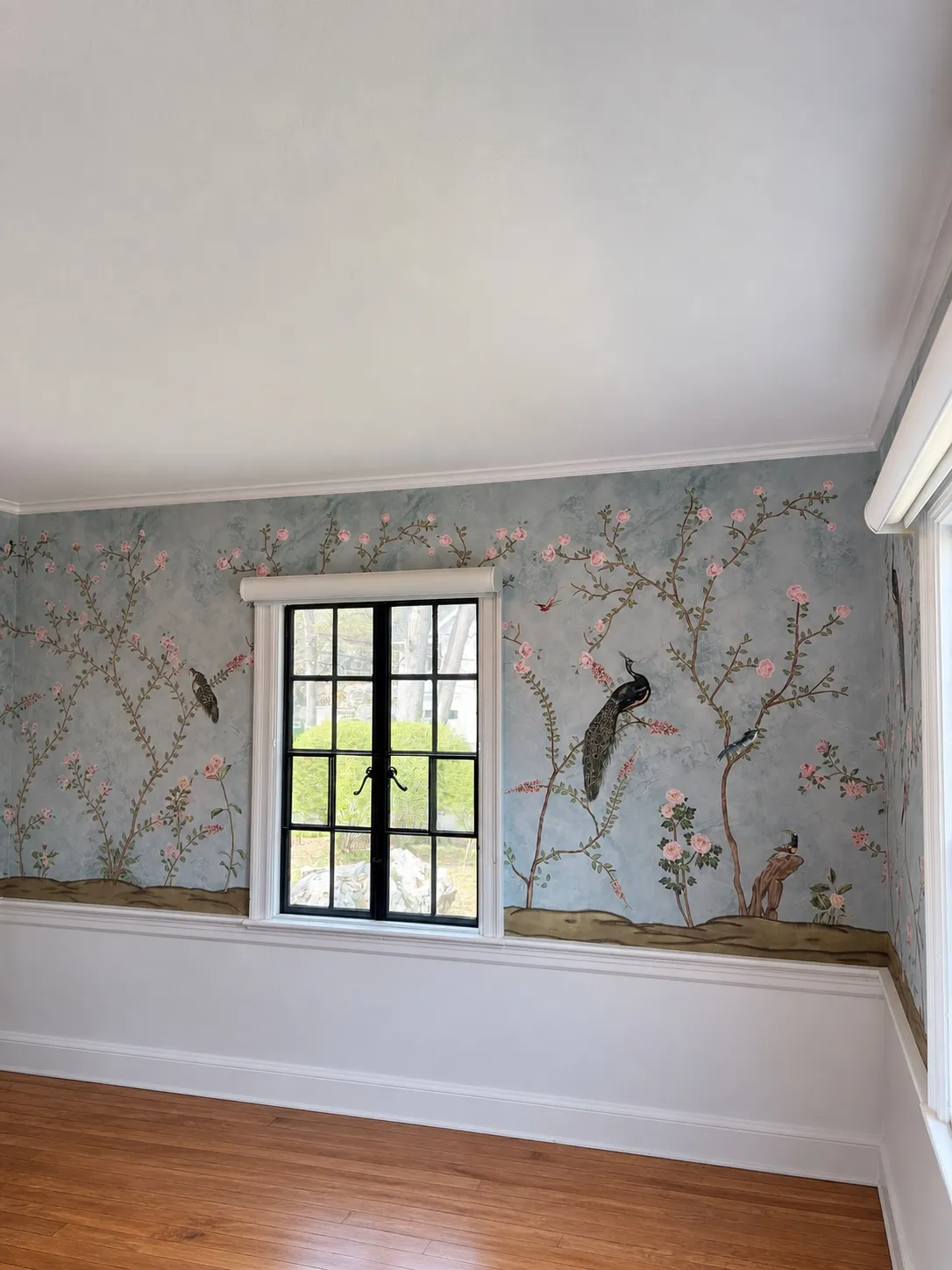Professional wallpaper installer working in a room